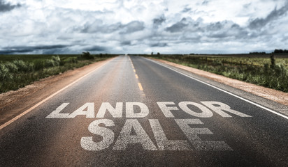 Land For Sale written on rural road