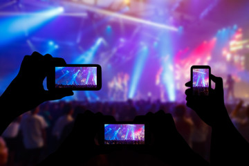 Take photo crowd in front of concert stage blurred