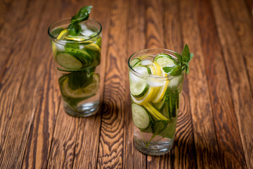 Water with lemon, mint and cucumber on wooden background. Water Detox.
