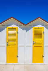 cabine da spiaggia bianche con porte gialle