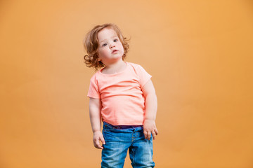 One cute baby girl on orange background