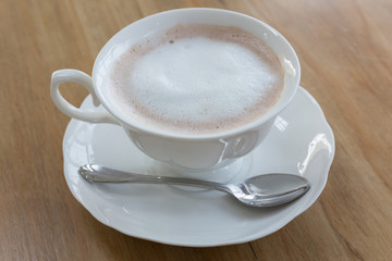 Fresh coffee in white cup on wooden table