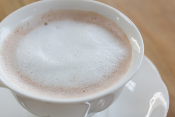 Fresh coffee in white cup on wooden table