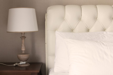 White pillow on white luxury bed in bedroom.