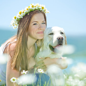 Beautiful woman with labrador on nature 