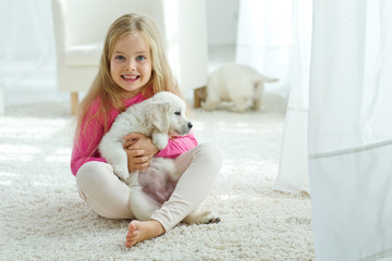 Little kid are playing with labrador puppies