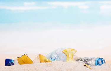 Fototapeta na wymiar Household and food waste in the sand on beach, background.