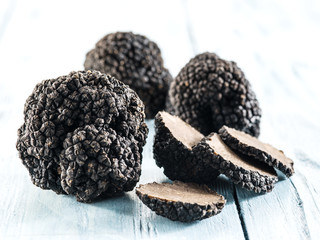 Black truffles on the old wooden table.