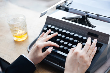 Woman's hands writing on old typewriter