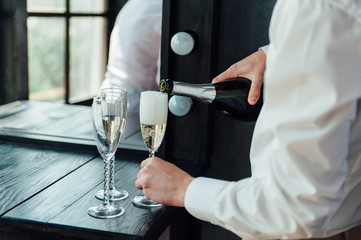men pour champagne into glasses