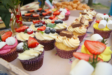 Delicious vanilla cupcake with strawberry frosting and fresh strawberries and blueberries