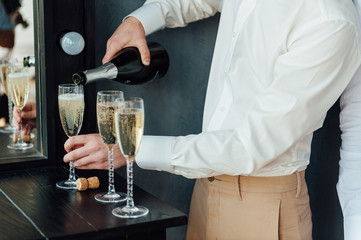 men pour champagne into glasses