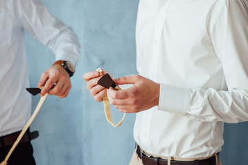 groom wears stylish bow tie using friend