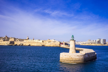 Fototapety  Valletta, Malta - stary most latarni morskiej i falochronu o poranku z błękitnym niebem