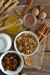 Walnuts, granola, milk and honey on wooden background
