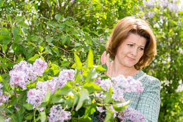 Woman suffering from allergy about lilacs