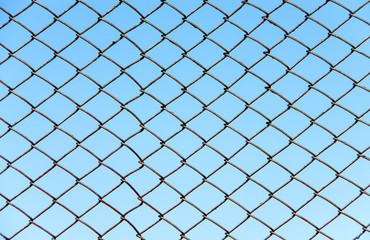fence of metal wire on a background blue sky