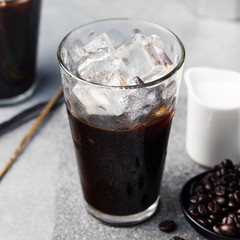 Ice coffee in a tall glass and coffee beans