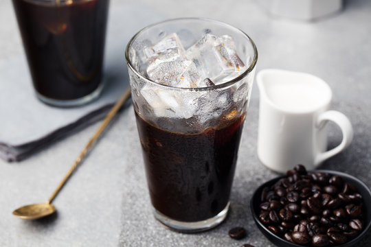 Ice coffee in a tall glass and coffee beans
