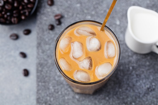 Ice coffee in a tall glass with cream and coffee beans Top view Copy space