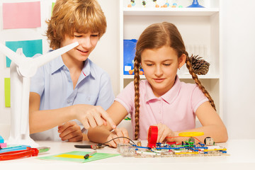 Teenage kids creating wind generator turbine model