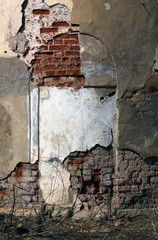 old ruined red brick wall of church with loose cracked white and