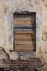 old ruined destroyed window without frame in old building is cho