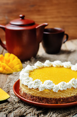 mango cheese cake decorated with whipped cream and mango puree