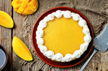 mango cheese cake decorated with whipped cream and mango puree