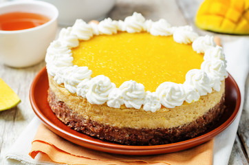 mango cheese cake decorated with whipped cream and mango puree