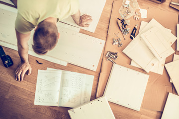 man furniture assembly instructions and laid on the floor side, top view