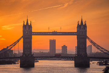 London, England - The iconic Tower Bridge at dawn with flying doves and orange sky
