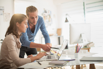 At office, two young creative colleague examining a project