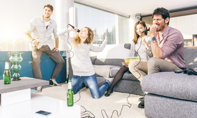 Group of friends playing karaoke at home
