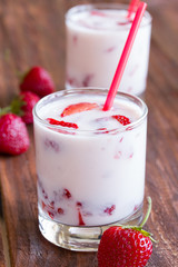 strawberry yogurt with strawberry pieces on a wooden table
