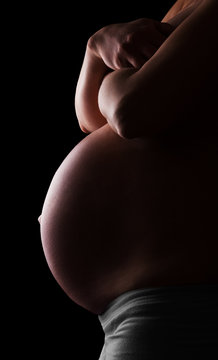 Belly  pregnant woman isolated on  black background.