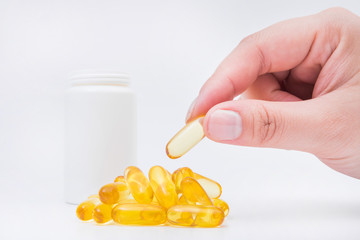 Omega 3 fish oil capsule hold by a hand