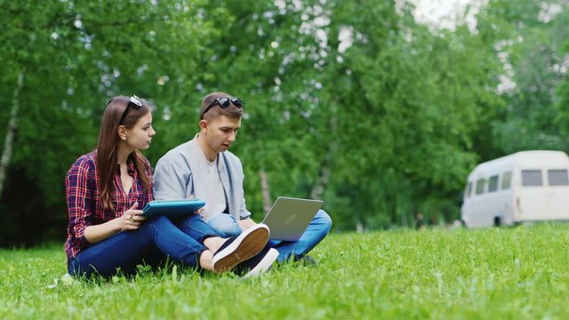 College students studying together in nature. Enjoy your tablet and laptop