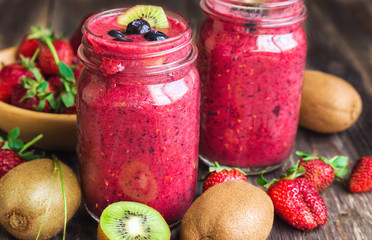 Smoothie with strawberries, kiwi and blueberries in jars