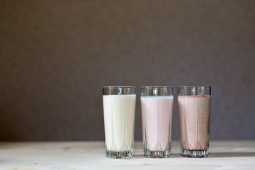 Fresh milk, chocolate, blueberry and banana drinks on table, assorted protein cocktails.