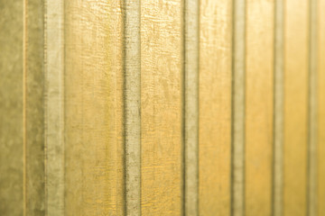 Corrugated yellow metal sheet wall