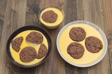flan de vainilla con galletas, sobre la mesa de madera
