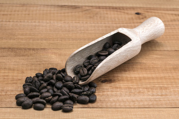 Coffee beans with wooden spoon on wooden table