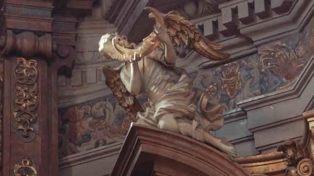 Angel with a crescent in hands. Church interior