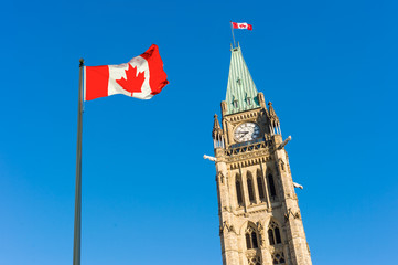 Canada Parliament and Canadian Flag over blue sky.