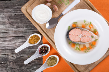 salmon soup with vegetables and dil, top view