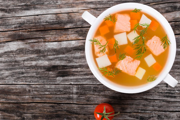 Salmon soup in white bowl top view