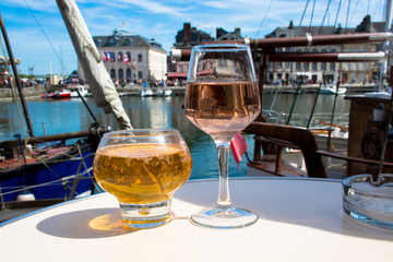 Glass with tasty apple cider and rose vine in old French fisherm