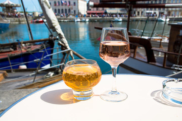 Glass with tasty apple cider and rose vine in old French fisherm