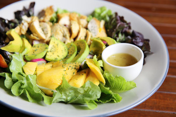 Salad with Chicken avocado and mango on wood background